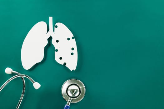 World Tuberculosis Day. Overhead lungs paper symbol and medical stethoscope on green background, lung cancer awareness, copy space concept of world TB day, banner background, pneumonia awareness