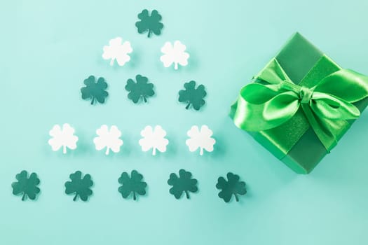 Happy St Patricks Day decoration background concept. shamrocks leaves holiday symbol with copy space on pastel background, above view gift box green clover leaves
