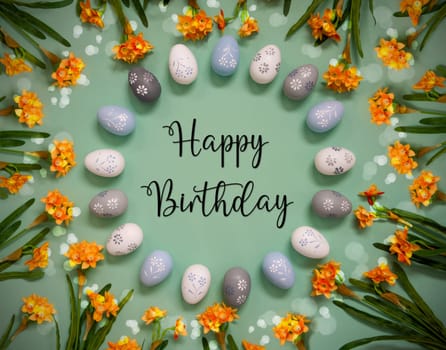 Flat Lay With English Text Happy Birthday. Easter Egg Decoration With Orange Spring Flowers. Light Green Paper Background With Bright And Shiny Light Effect.