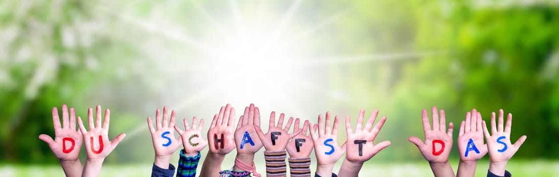 Children Hands Building Colorful German Word Du Schaffst Das Means You Can Do It. Sunny Green Grass Meadow As Background.