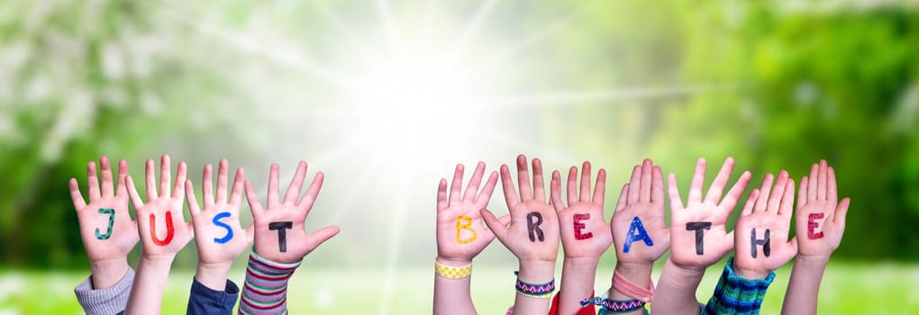 Children Hands Building Colorful English Word Just Breathe. Sunny Green Grass Meadow As Background.