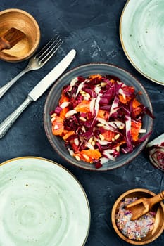 Tasty salad with chicory or radicchio, grapefruit and pine nuts on the table