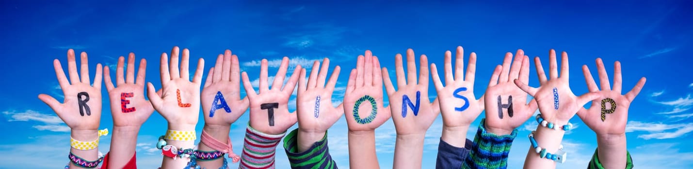 Children Hands Building Colorful English Word Relationship. Blue Sky As Background