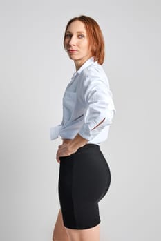 Portrait of adult woman in tight mini skirt and white shirt in profile