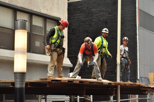 YMCA, four construction workers on a canopy in New York