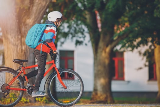 Teenager in the morning quickly riding on bicycle to the lesson. Concept of the back to school.