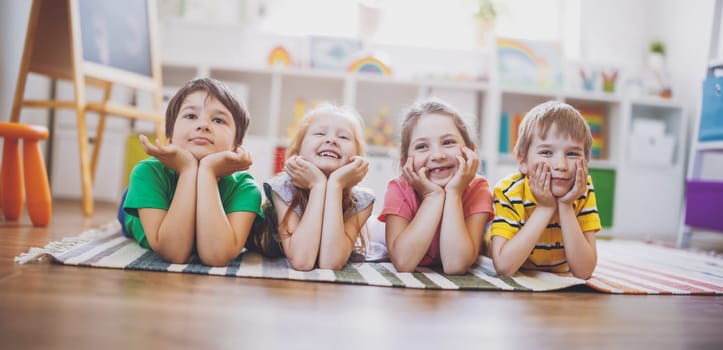 Group of children lying on the floor and looking in the camera. Concept of relationship, friendship and education.