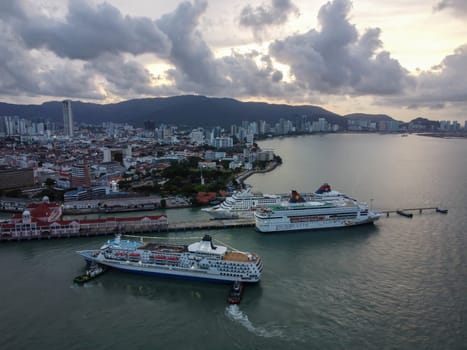 George Town, Penang, Malaysia - May 27 2022: Aerial view tug boat move the Aegean Paradise cruise ship arrive Georgetown Port