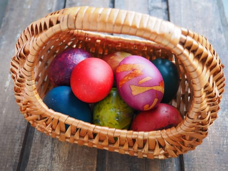 Happy Easter. Easter colored eggs in a wicker basket on a wooden table. Easter, the Resurrection of Christ, the Bright Resurrection of Christ, the most ancient and Christian holiday
