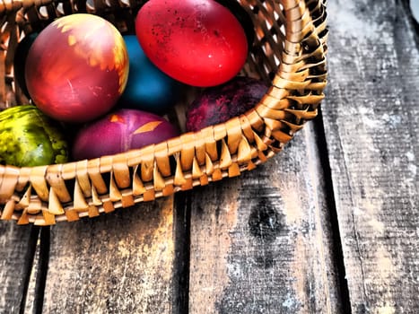 Happy Easter. Easter colored eggs in a wicker basket on a wooden table. Easter, the Resurrection of Christ, the Bright Resurrection of Christ, the most ancient and Christian holiday