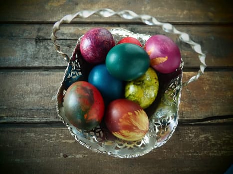 Easter colored eggs in an old metal candy bowl on a wooden table. Easter, the Resurrection of Christ, the Bright Resurrection of Christ, the most ancient and Christian holiday.