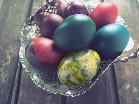 Easter colored eggs in an old metal candy bowl on a wooden table. Easter, the Resurrection of Christ, the Bright Resurrection of Christ, the most ancient and Christian holiday.