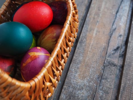 Happy Easter. Easter colored eggs in a wicker basket on a wooden table. Easter, the Resurrection of Christ, the Bright Resurrection of Christ, the most ancient and Christian holiday