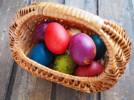 Happy Easter. Easter colored eggs in a wicker basket on a wooden table. Easter, the Resurrection of Christ, the Bright Resurrection of Christ, the most ancient and Christian holiday