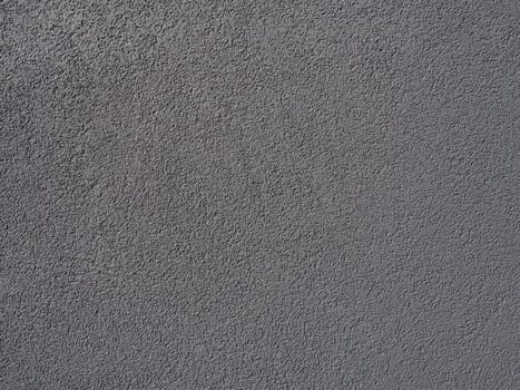 Gray background. Neatly plastered gray or black wall. Rough texture. Velvety effect. Professional finishing of walls, interiors, facades of buildings and premises. Construction and design.