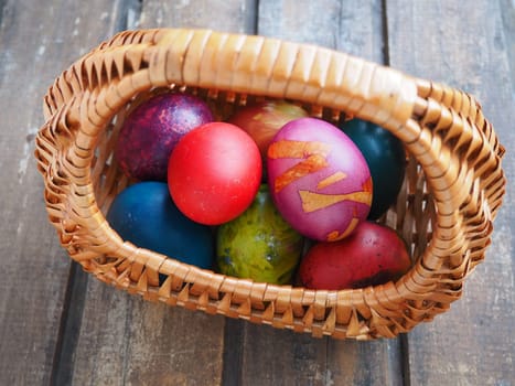Happy Easter. Easter colored eggs in a wicker basket on a wooden table. Easter, the Resurrection of Christ, the Bright Resurrection of Christ, the most ancient and Christian holiday
