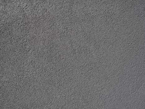 Gray background. Neatly plastered gray or black wall. Rough texture. Velvety effect. Professional finishing of walls, interiors, facades of buildings and premises. Construction and design.