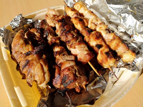 Home delivery food. Grilled chicken, pork skewers on sticks. Food from the restaurant. Dish in disposable plastic packaging. Beef patties, chevapy. Food delivery during self-isolation.