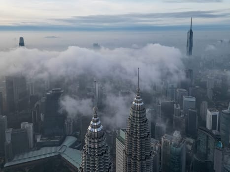 Bukit Bintang, Kuala Lumpur, Malaysia - Nov 13 2022: The surrounding KLCC, Merdeka 118 appears dreamlike and mystical, with the low-lying clouds adding to the effect.