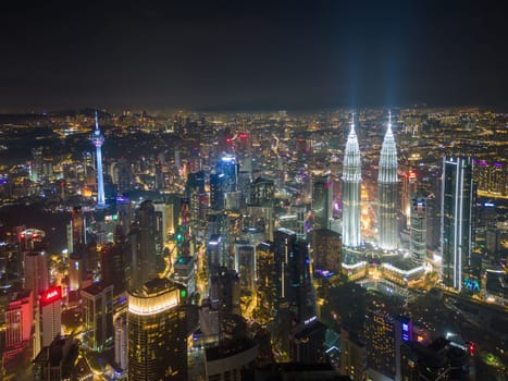Bukit Bintang, Kuala Lumpur, Malaysia - Nov 29 2022: The Petronas Twin Towers stand tall, illuminated against the dark sky