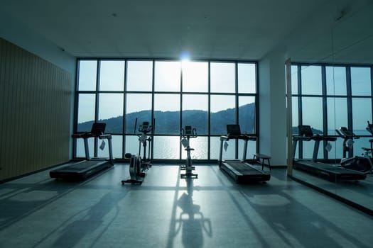 Bayan Lepas, Penang, Malaysia - Nov 16 2021: Group of running machine in gym room in backlight of sun light
