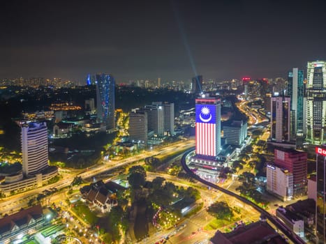 Bukit Bintang, Kuala Lumpur, Malaysia - Nov 28 2022: Merdeka flag at the DBKL tower in night near Dataran Merdeka. Aerial view