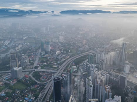 Bukit Bintang, Kuala Lumpur, Malaysia - Nov 13 2022: Aerial morning misty cloud at Kuala Lumpur city building and highway