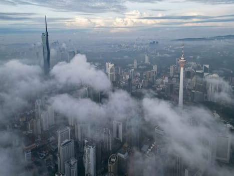 Bukit Bintang, Kuala Lumpur, Malaysia - Nov 13 2022: The low cloud cover creates a dramatic effect, highlighting the KL Tower and Merdeka 118 making it look larger than life.