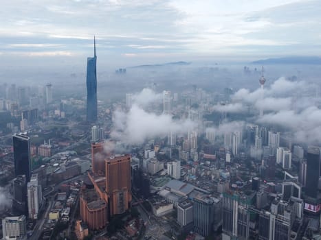 Bukit Bintang, Kuala Lumpur, Malaysia - Nov 13 2022: The misty low cloud cover seems to blanket the cityscape, creating an enchanting atmosphere around Merdeka 118.