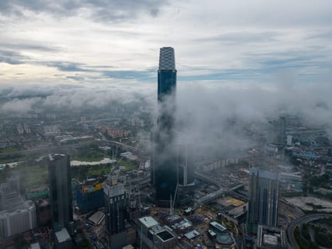 Bukit Bintang, Kuala Lumpur, Malaysia - Dec 03 2022: The surrounding skyscrapers and cityscape look miniature in comparison to the towering Exchange 106.