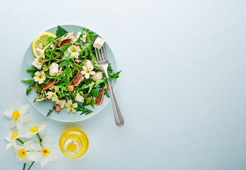 Spring salad with dandelion, asparagus, wild garlic, flowers, nettle and cheese. Healthy food for spring detox