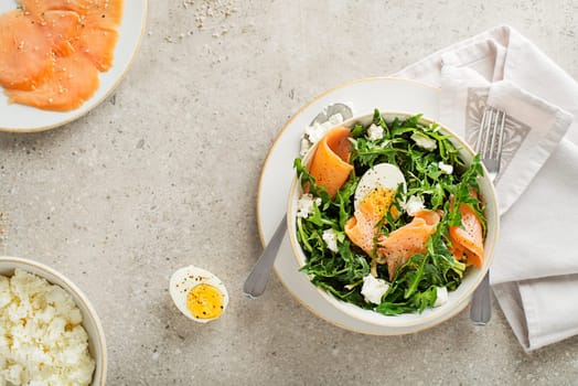 Dandelion salad with smoked salmon, egg and fresh cheese close up
