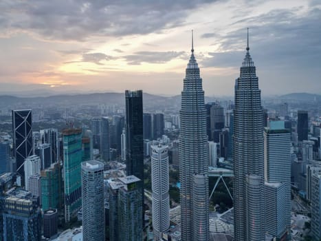 Bukit Bintang, Kuala Lumpur, Malaysia - Dec 25 2022: The city's iconic landmarks the KLCC Petronas Twin Towers in sunrise