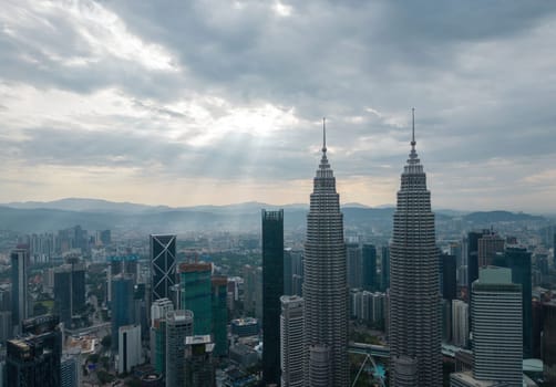 Bukit Bintang, Kuala Lumpur, Malaysia - Dec 25 2022: The city's iconic landmarks the Petronas Twin Towers in sun ray morning