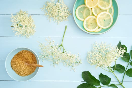 Elderflowers,sugar and lemons for making elderflower syrup on a table