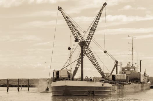 Effect vintage. Dredger ship navy working to clean a navigation channel