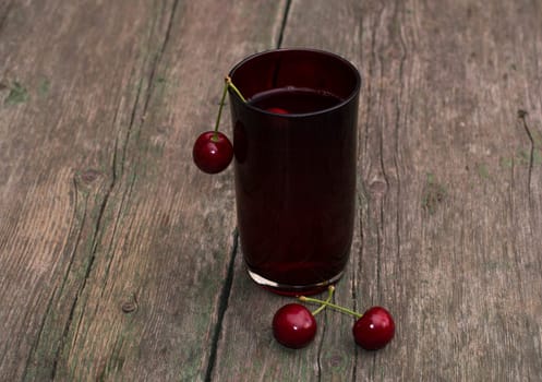 the glass of juice decorated with berries of red sweet cherry, the image of drink