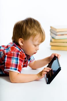 Little boy lying on the floor with tablet computer