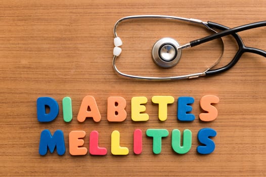 diabetes mellitus colorful medical word and stethoscope on the wooden background