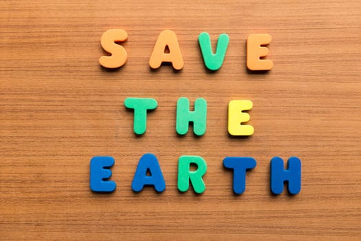 save the earth colorful words on the wooden background