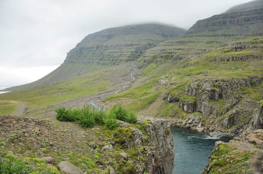 Scenic view of a river flowing between grass cliffs in Iceland