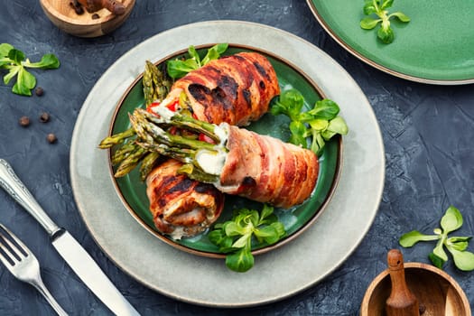 Meatloaf wrapped in bacon. Roasted green asparagus wrapped with meat . Top view