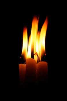 sacred candles in dark on black background