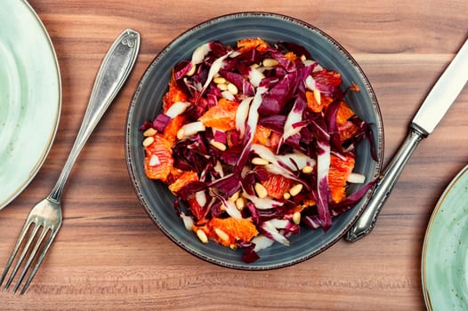 Diet chicory salad with grapefruit and pine nuts on a plate. Flat lay.