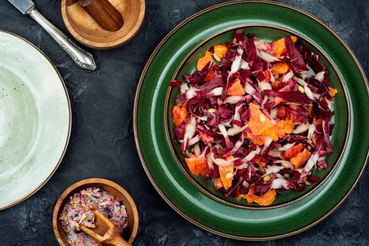 Diet chicory salad with grapefruit and pine nuts on a plate. Flat lay.