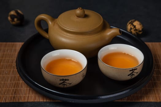 Hot green tea in clay Chinese cups and clay teapot. An old Chinese tradition.