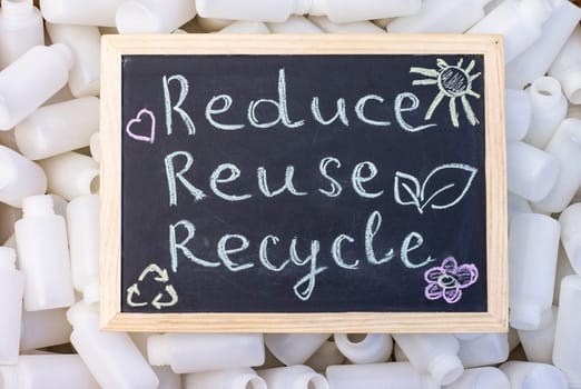 Chalk board Reduse Reuse Recycle sign on the background of empty plastic packaging. Top view