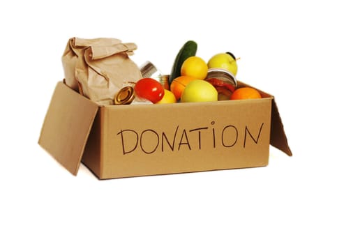 Various food in a cardboard donation box, isolated.