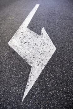 Detail of a traffic signal on a road, direction arrow and information