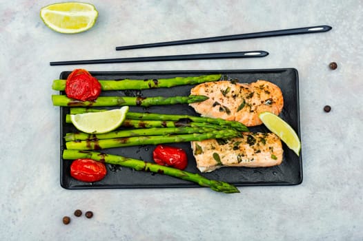 Tasty dish of trout, asparagus and tomato. Space for text.